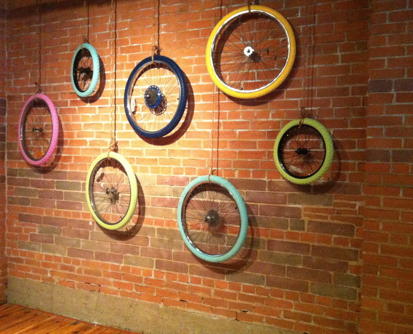 Painted bicycle wheels - art hanging in the Mercer building - Startup Edmonton