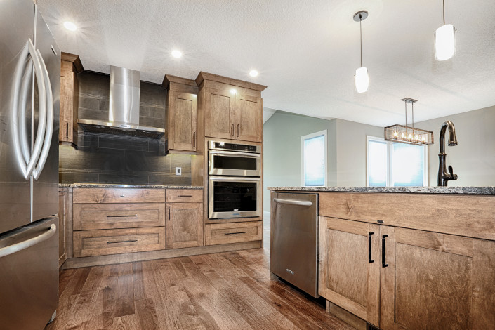 stainless steel hood fan, double ovens. By House of J Interior Design. Edmonton, Alberta.