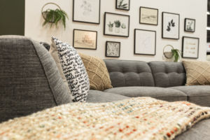 Collage wall of art. Original art. Toss cushions and throw on grey tufted sectional.